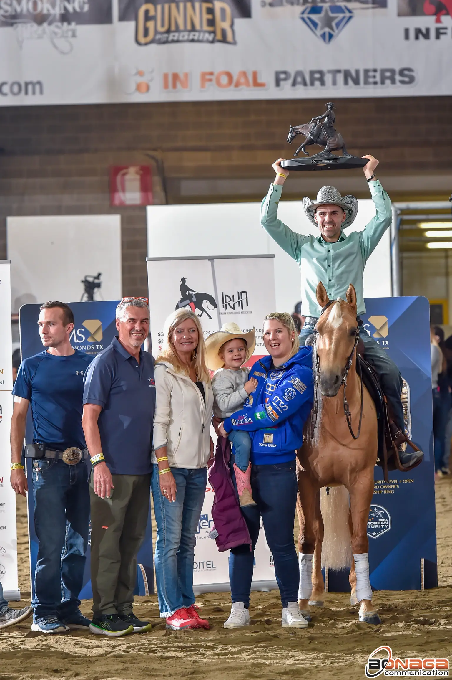 Kevin Paquet hebt im Sattel die Futurity-Trophäe über den Kopf, umgeben von seinem Team